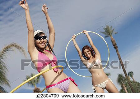 Stock Photo - Young women in bikinis with hoops. Fotosearch