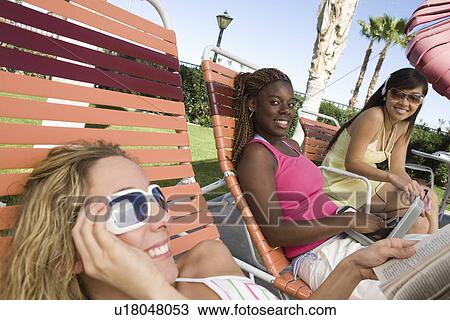 Stock Image - Young women relaxing outdoors. Fotosearch