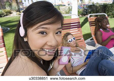 Stock Image - Young women relaxing outdoors. Fotosearch