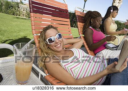 Stock Photograph - Young women relaxing outdoors. Fotosearch