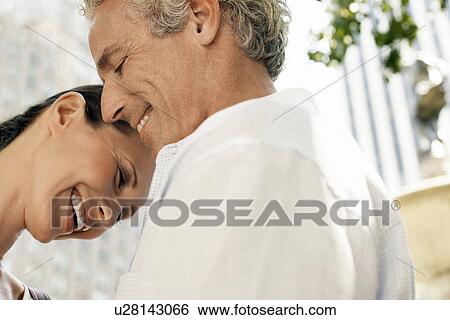 Affectionate couple smiling outdoors, close-up View Large Photo Image Stock Photograph - Affectionate couple smiling outdoors, close-up. Fotosearch