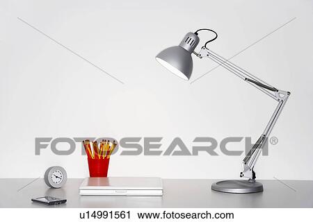 Angle poise lamp, laptop, clock, pencils and PDA on desk View Large Photo Image Stock Image - Angle poise lamp, laptop, clock, pencils and PDA on desk. Fotosearch