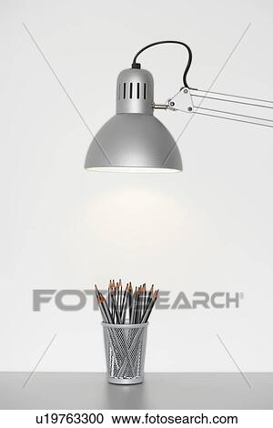 Angle poise lamp shining on cup of pencils View Large Photo Image Stock Image - Angle poise lamp shining on cup of pencils. Fotosearch