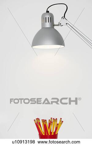 Angle poise lamp shining on cup of pencils View Large Photo Image Stock Photo - Angle poise lamp shining on cup of pencils. Fotosearch