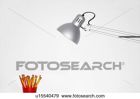 Angle poise lamp shining on cup of pencils View Large Photo Image Stock Photo - Angle poise lamp shining on cup of pencils. Fotosearch