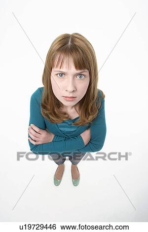 Stock Photograph - Angry-looking teenage Girl, arms crossed, elevated view. Fotosearch