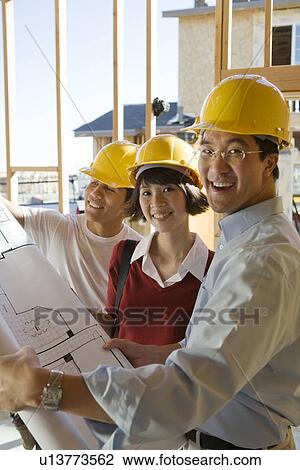 Architects with blueprints on construction site View Large Photo Image Stock Image - Architects with blueprints on construction site. Fotosearch