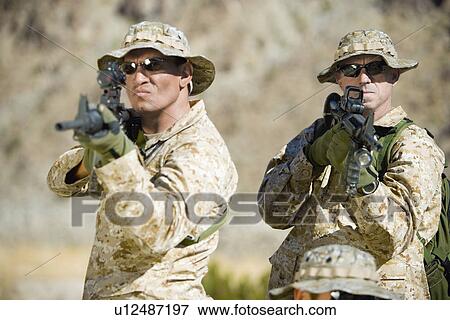 Stock Photo - Armed soldiers standing side by side, outdoors. Fotosearch