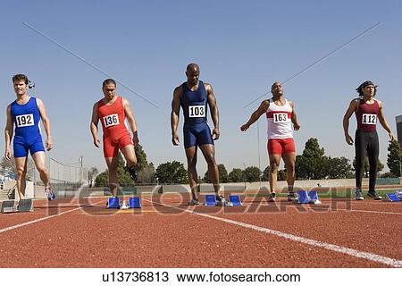 Athletes standing next to starting blocks, ready to run View Large Photo Image Stock Image - Athletes standing next to starting blocks, ready to run. Fotosearch