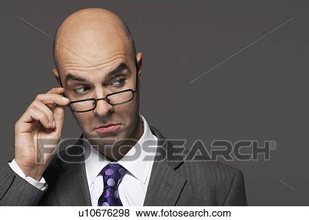 Balding businessman hand on glasses, making a face View Large Photo Image Stock Photo - Balding businessman hand on glasses, making a face. Fotosearch