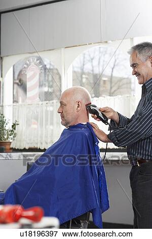 Barber shaving mans head in barber shop View Large Photo Image Stock Photo - Barber shaving mans head in barber shop. Fotosearch