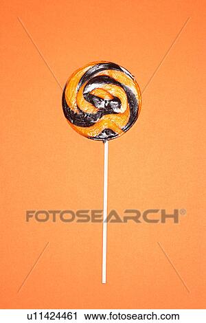 Black and orange lollypop on orange background View Large Photo Image Stock Image - Black and orange lollypop on orange background. Fotosearch