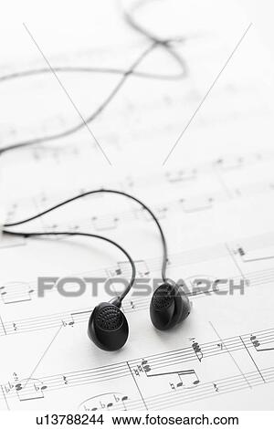 Picture - Black headphones on sheet music. Fotosearch