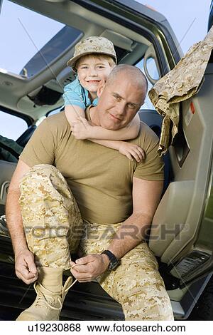 Boy (5-6) embracing military father in vehicle, (portrait) View Large Photo Image Stock Photo - Boy (5-6) embracing military father in vehicle, (portrait). Fotosearch