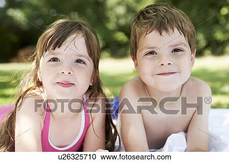 Boy and girl lying in backyard, portrait, close up View Large Photo Image Stock Image - Boy and girl lying in backyard, portrait, close up. Fotosearch