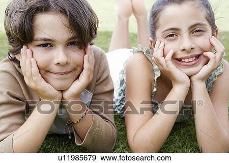 Stock Photo - Boy and Girl Lying on Lawn. Fotosearch