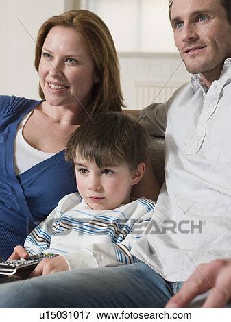 Stock Photo - Boy Between Parents Watching Television. Fotosearch