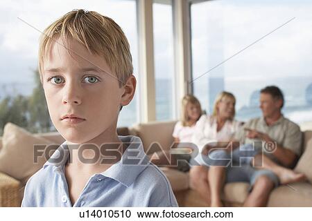 Boy Standing in Room with Family in Background View Large Photo Image Stock Image - Boy Standing in Room with Family in Background. Fotosearch