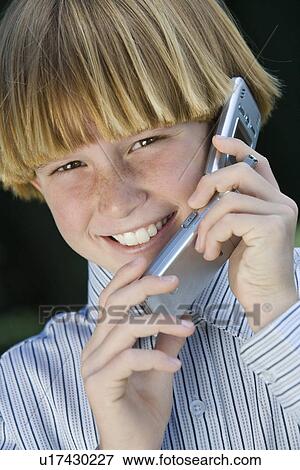 Stock Photo - Boy with mobile phone, smiling. Fotosearch