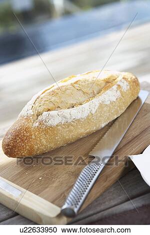 Bread Roll on cutting board on picnic table with bread knife View Large Photo Image Stock Image - Bread Roll on cutting board on picnic table with bread knife. Fotosearch