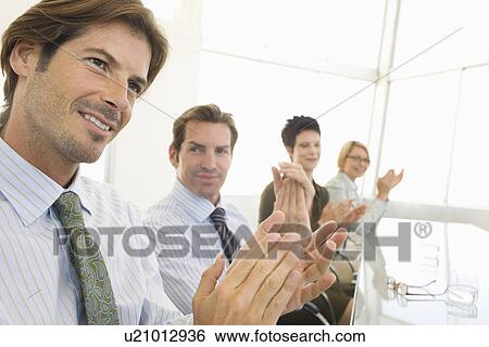 Stock Photograph - Business colleagues applauding in conference meeting. Fotosearch