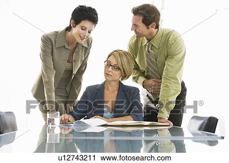 Stock Image - Business colleagues working in conference room. Fotosearch