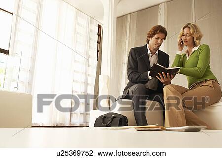 Business couple talking in living room, low angle view View Large Photo Image Stock Image - Business couple talking in living room, low angle view. Fotosearch