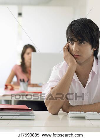 Business man at desk looking bored View Large Photo Image Stock Photography - Business man at desk looking bored. Fotosearch