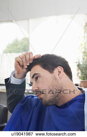 Business man holding freshly cut hair in barbers View Large Photo Image Stock Photo - Business man holding freshly cut hair in barbers. Fotosearch