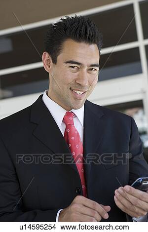 Picture - Business man holding mobile phone, portrait. Fotosearch