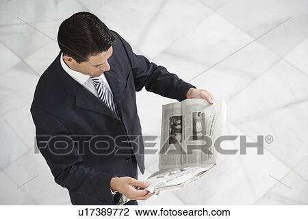 Business man reading newspaper indoors View Large Photo Image Stock Image - Business man reading newspaper indoors. Fotosearch