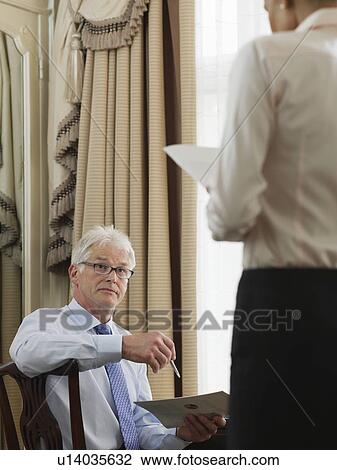 Business man sitting at desk, looking at business woman standing View Large Photo Image Stock Image - Business man sitting at desk, looking at business woman standing. Fotosearch