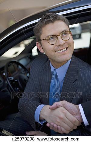 Business man sitting in car, shaking hands View Large Photo Image Stock Photo - Business man sitting in car, shaking hands. Fotosearch