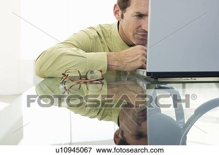 Stock Photo - Business man using laptop in office. Fotosearch