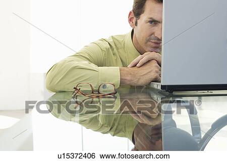 Stock Photograph - Business man using laptop in office. Fotosearch