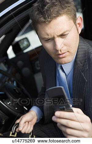 Business man using mobile phone in car View Large Photo Image Stock Photo - Business man using mobile phone in car. Fotosearch