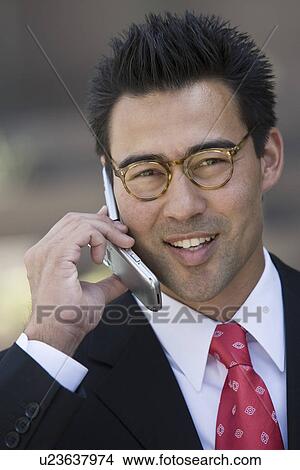 Picture - Business man using mobile phone, outdoors. Fotosearch