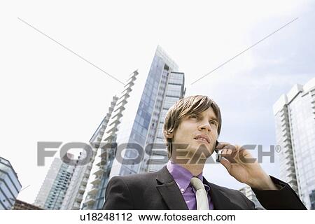Business man using mobile phone, outside office buildings View Large Photo Image Stock Image - Business man using mobile phone, outside office buildings. Fotosearch