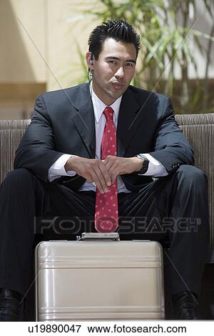 Stock Photo - Business man with briefcase indoors, portrait. Fotosearch