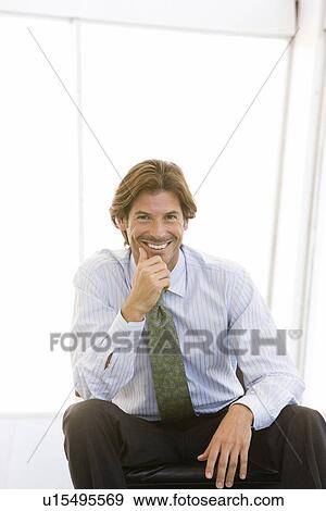 Stock Photo - Business man with hand on chin, portrait. Fotosearch
