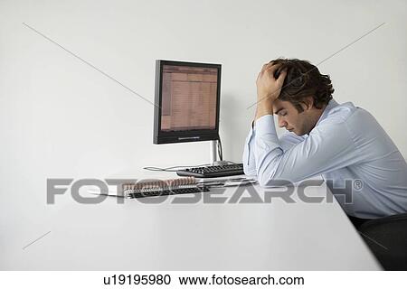 Business man with head in hands sitting at office desk, side view View Large Photo Image Stock Image - Business man with head in hands sitting at office desk, side view. Fotosearch