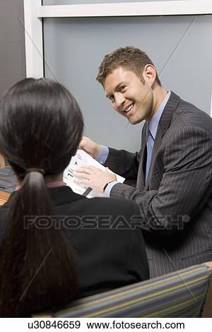 Stock Photo - Business people having meeting. Fotosearch