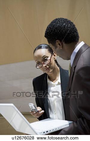 Business people using laptop and mobile phone View Large Photo Image Stock Photo - Business people using laptop and mobile phone. Fotosearch
