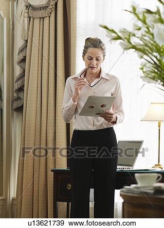 Business woman reading document in home office View Large Photo Image Stock Photo - Business woman reading document in home office. Fotosearch