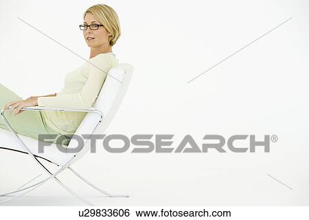 Stock Photograph - Business woman sitting in chair, portrait. Fotosearch