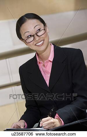 Business woman smiling and writing notes View Large Photo Image Stock Photograph - Business woman smiling and writing notes. Fotosearch