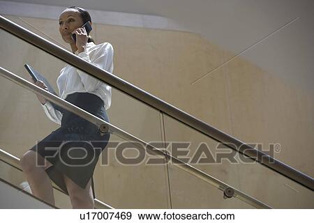 Business woman using mobile phone on stairs View Large Photo Image Stock Photo - Business woman using mobile phone on stairs. Fotosearch