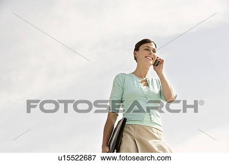 Stock Photo - Business woman Using mobile phone Outdoors, low angle view.. Fotosearch