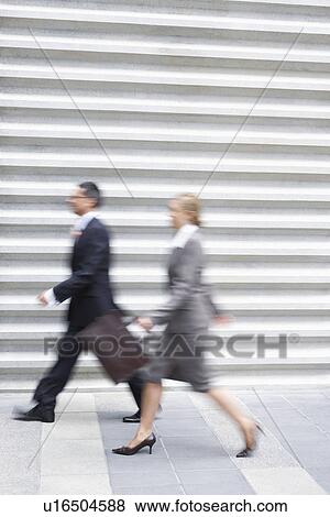 Businessman and businesswoman walking quickly, side view View Large Photo Image Stock Photo - Businessman and businesswoman walking quickly, side view. Fotosearch