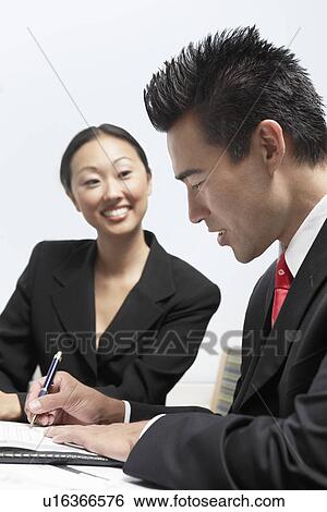Businessman and Businesswoman Writing Notes in Office View Large Photo Image Stock Photograph - Businessman and Businesswoman Writing Notes in Office. Fotosearch